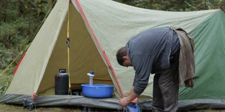 Mann wäscht sein Campingzelt (NF)
