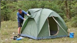Mann reinigt Campingzelt (NF)